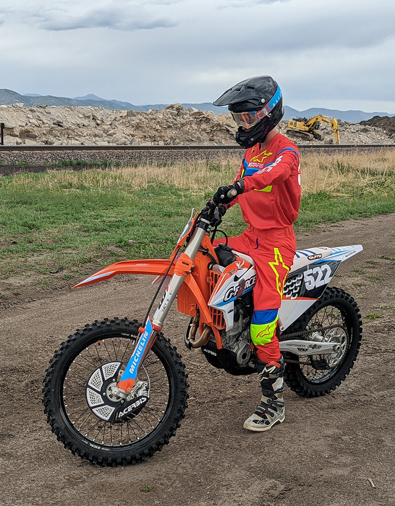 Grayson in full motocross gear, sitting on a dirt bike